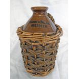 STONEWARE FLAGON MARKED FARQUHAR & GILL LTD, ABERDEEN IN WICKER BASKET.