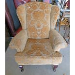 OVERSTUFFED WINGBACK ARMCHAIR WITH GOLD FLORAL PATTERN ON QUEEN ANNE SUPPORTS