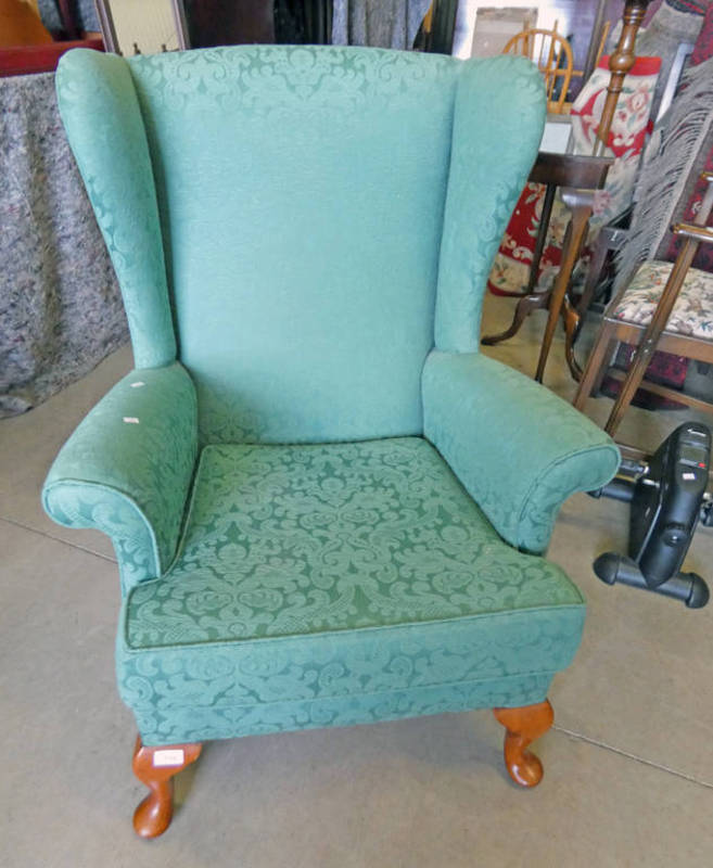 OVERSTUFFED WINGBACK ARMCHAIR WITH GREEN FLORAL PATTERN ON QUEEN ANNE SUPPORTS