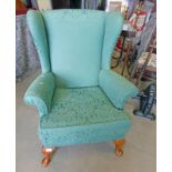 OVERSTUFFED WINGBACK ARMCHAIR WITH GREEN FLORAL PATTERN ON QUEEN ANNE SUPPORTS