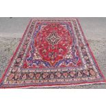 RED GROUND PERSIAN SHAHROKH CARPET WITH CENTRAL MEDALLION DESIGN 310 X 225CM