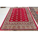 RICH RED GROUND KASHMIR FULL PILE RUG WITH A TRADITIONAL BUKHARA DESIGN 119 X 170CM