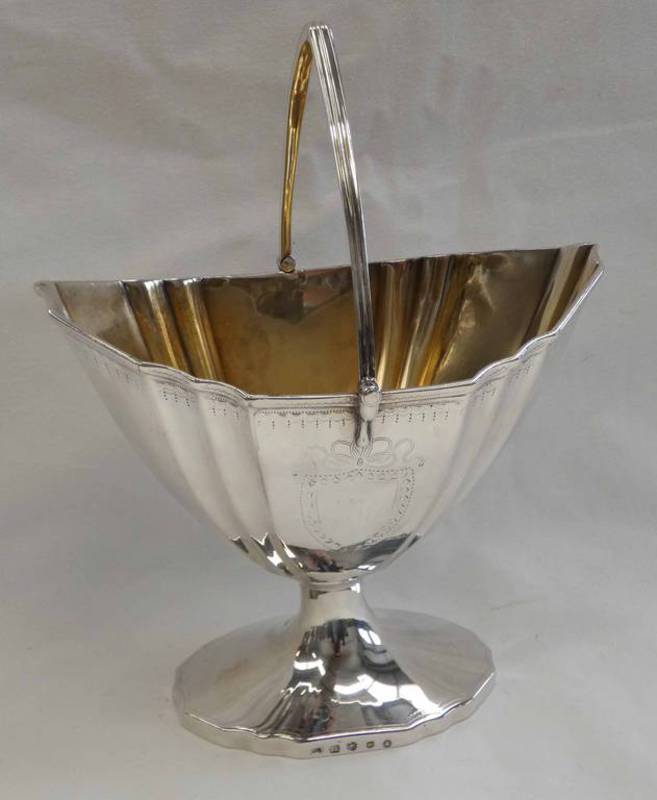 GEORGE III SCOTTISH SILVER SWING HANDLED SWEET MEAT BASKET WITH GILT INTERIOR ON SHAPED OVAL BASE,