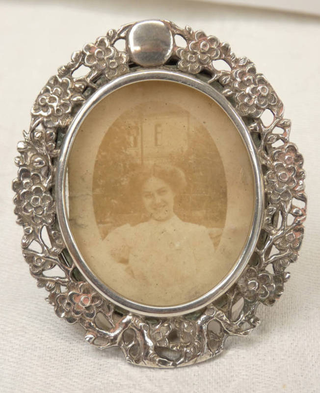 CHINESE SILVER OVAL PHOTO FRAME DECORATED WITH FLOWERS, MARKS TO RIM, 6 X 5.