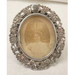 CHINESE SILVER OVAL PHOTO FRAME DECORATED WITH FLOWERS, MARKS TO RIM, 6 X 5.