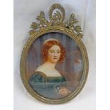 GILT METAL FRAMED PORTRAIT MINIATURE OF A YOUNG LADY SEATED BY A WINDOW HOLDING A PRAYER BOOK - 6 X