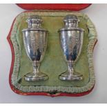 PAIR OF VICTORIAN SILVER PEPPERS ENGRAVED WITH FLORAL SWAGS IN A FITTED CASE,