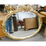 LARGE OVAL MIRROR WITH DECORATIVE CARVED GILT FRAME 86 CM TALL X 115 CM WIDE
