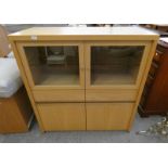 MODERN OAK CABINET WITH GLASS SHELVES BEHIND 2 GLAZED PANEL DOORS OVER 2 DRAWERS AND 2 PANEL DOORS