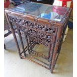 NEST OF 4 EASTERN HARDWOOD TABLES WITH ORIENTAL CARVING & GLASS INSET TOPS