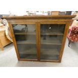 OAK BOOKCASE WITH ADJUSTABLE SHELVES BEHIND 2 GLAZED PANEL DOORS 109 CM TALL X 121 CM WIDE