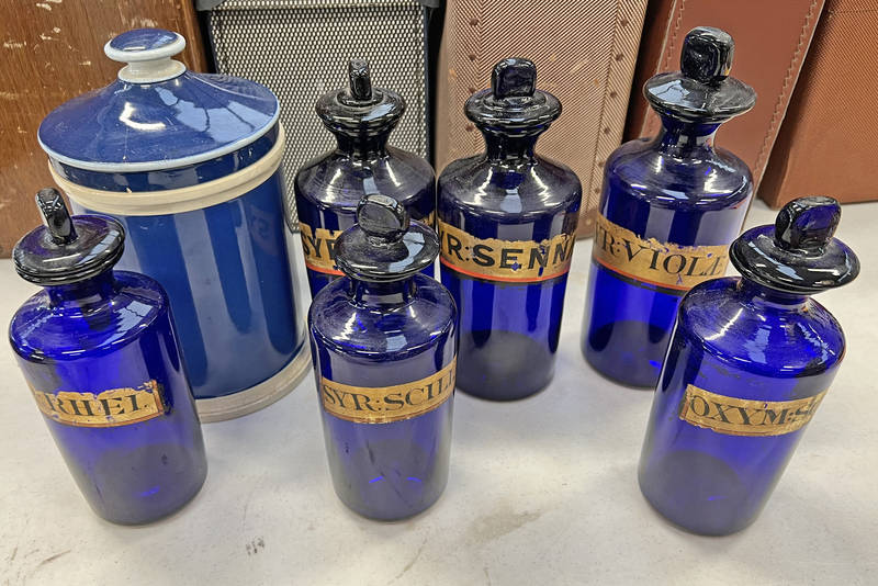 6 BLUE GLASS CHEMIST BOTTLES AND A WHITE AND BLUE PORCELAIN CHEMISTS JAR - 7 Condition