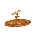 A 15 carat gold diamond brooch, an old cut diamond in a yellow claw setting, within a bead and