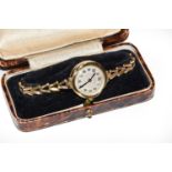 A lady's gold wristwatch; and an 18 carat gold band ring, finger size PCondition report: Watch -