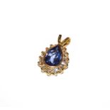A tanzanite and diamond cluster pendant, the pear shaped tanzanite in a yellow rubbed over