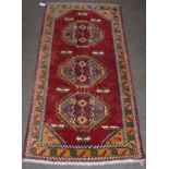 Kars rug, the claret field with three hooked octagonal medallions enclosed by narrow borders,