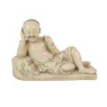 A Chinese Soapstone Figure of a Man, Qing Dynasty, probably 18th century, recumbent with hair