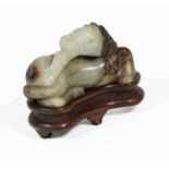 A Chinese Celadon and Russet Jade Horse, Ming Dynasty, worked recumbent on its side, 6cm long, on