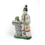 A Chinese Porcelain Figure of a Maiden, Qianlong, standing wearing floral decorated robes beside a