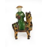 A Chinese Sancai Glazed Porcelain Figure Group, Kangxi, as a scholar on horseback, picked out in