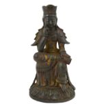 A Chinese Bronze Figure of a Deity, in Ming style, seated on a stool, wearing a cap and flowing