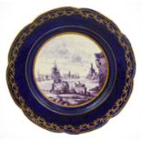 A Tournai-Style Porcelain Plate, in 18th century style, painted in puce monochrome with a harbour