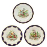 A Set of Three Tournai-Style Porcelain Plates, in 18th century style, painted with exotic birds