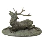 Holme Cardwell: A Green Patinated Bronze Figure of a Stag, recumbent on a mound base, signed HOLME