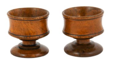 A Pair of Turned Treen Salts, early 19th century, the waisted cylindrical bowls on similar stems and