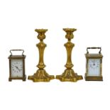 A pair of gilt bronze candlesticks with detachable nozzles, a brass carriage timepiece, and