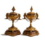 A pair of French gilt metal Classical style urns, 19th century, surmounted by griffin handles and