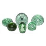 Six Victorian Stourbridge green glass dumps, one containing a figure, another with opaque striped