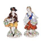 A pair of 20th century Sitzendorf seated figures, one as a gentleman with a basket of flowers, the