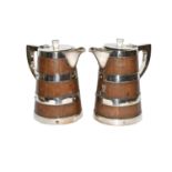 A pair of early 20th century staved oak jugs, with silver plated mounts and pot liners, one