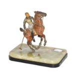 An early 20th century cold painted sculpture of a polo player in action, raised on an onyx and slate