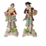 A pair of 20th century Sitzendorf figures carrying game and baskets of flowers