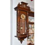 A walnut veneered Vienna type striking wall clock, twin spring barrel movement striking on a gong,