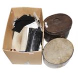 Gents costume accessories, comprising: a small black top hat and larger example in a tin box (brim