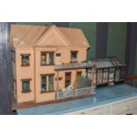 Victorian painted two storey dollhouse with veranda, together with a Victorian doll's conservatory