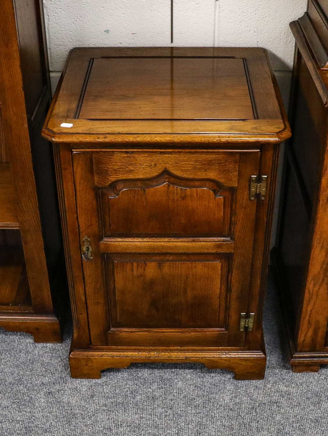 A Titchmarsh & Goodwin oak entertainment cabinet with lift up top and carved panel door, 53cm by