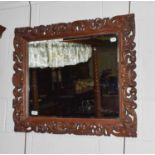 A late 19th century Flemish carved walnut wall mirror, adorned with pierced scrollwork and shell