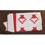 A modern red and white quilt appliqued with baskets of flowers, within a red trim, white reverse,