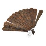 An early 19th century carved tortoiseshell brisee fan, comprising fifteen sticks and one guard,