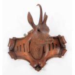 A Carved Black Forest Whip Rack, in the form of an Alpine Chamois head mount, the carved shield with