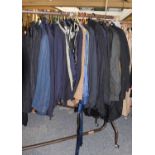 Rail of assorted gents suits, jackets, trousers, beige mac, leather boots and shoes, white evening