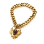 A curb link bracelet, stamped '18', with a garnet clasp with a hair work locket compartment to the
