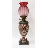 A Zsolnay pottery oil lamp with brass mounts, chimney and pink glass shade, and an Oriental carved