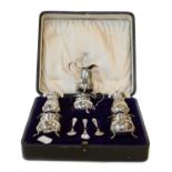A cased George V silver cruet set, Birmingham, 1918, an Edward VII silver cream jug, Birmingham,