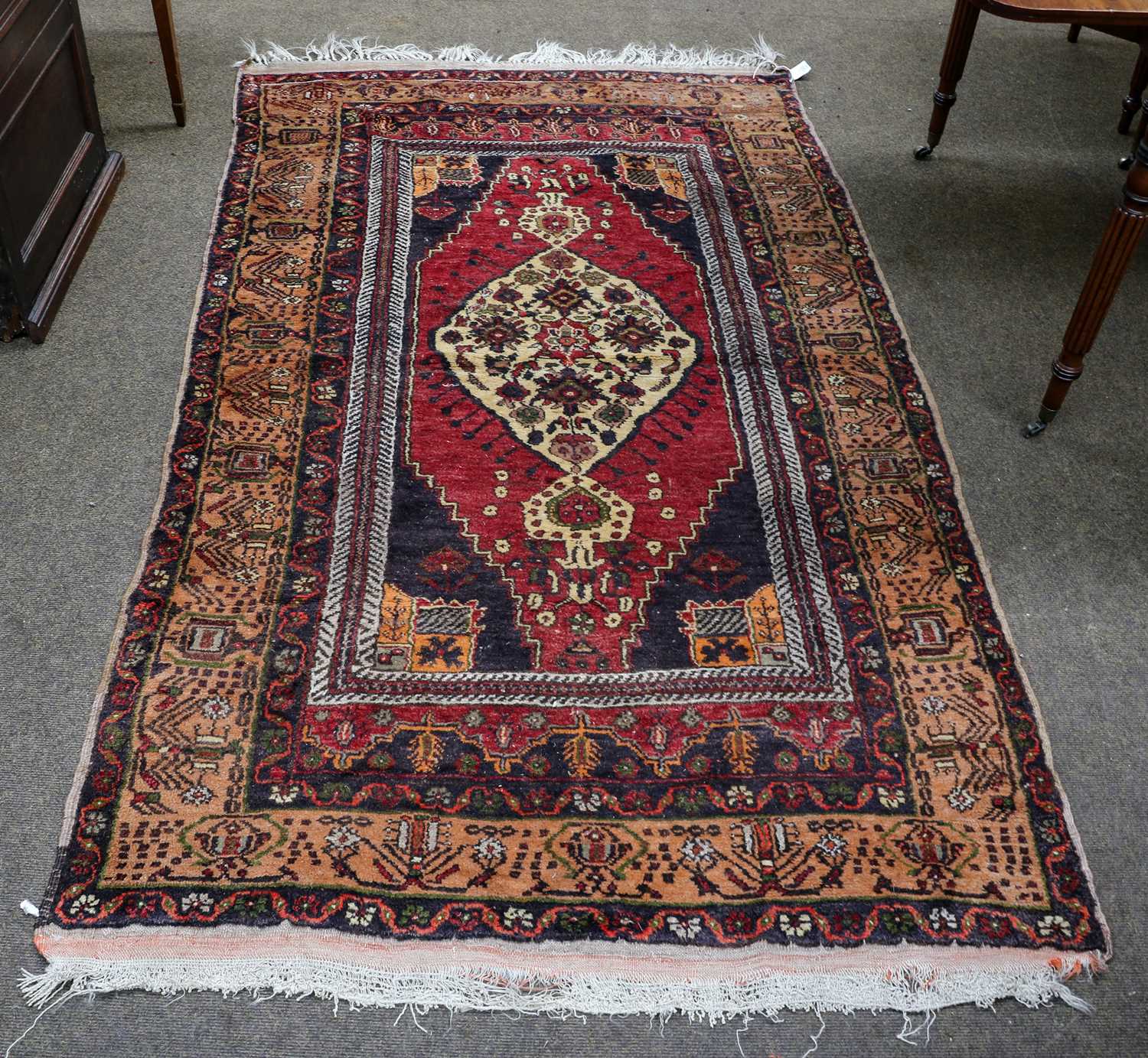 An Anatolian rug, the raspberry field with ivory medallion, enclosed by peach borders and