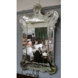 A Venetian style mirror applied with moulded flower heads and with etch frame, 114cm by 71cm (a/f.)